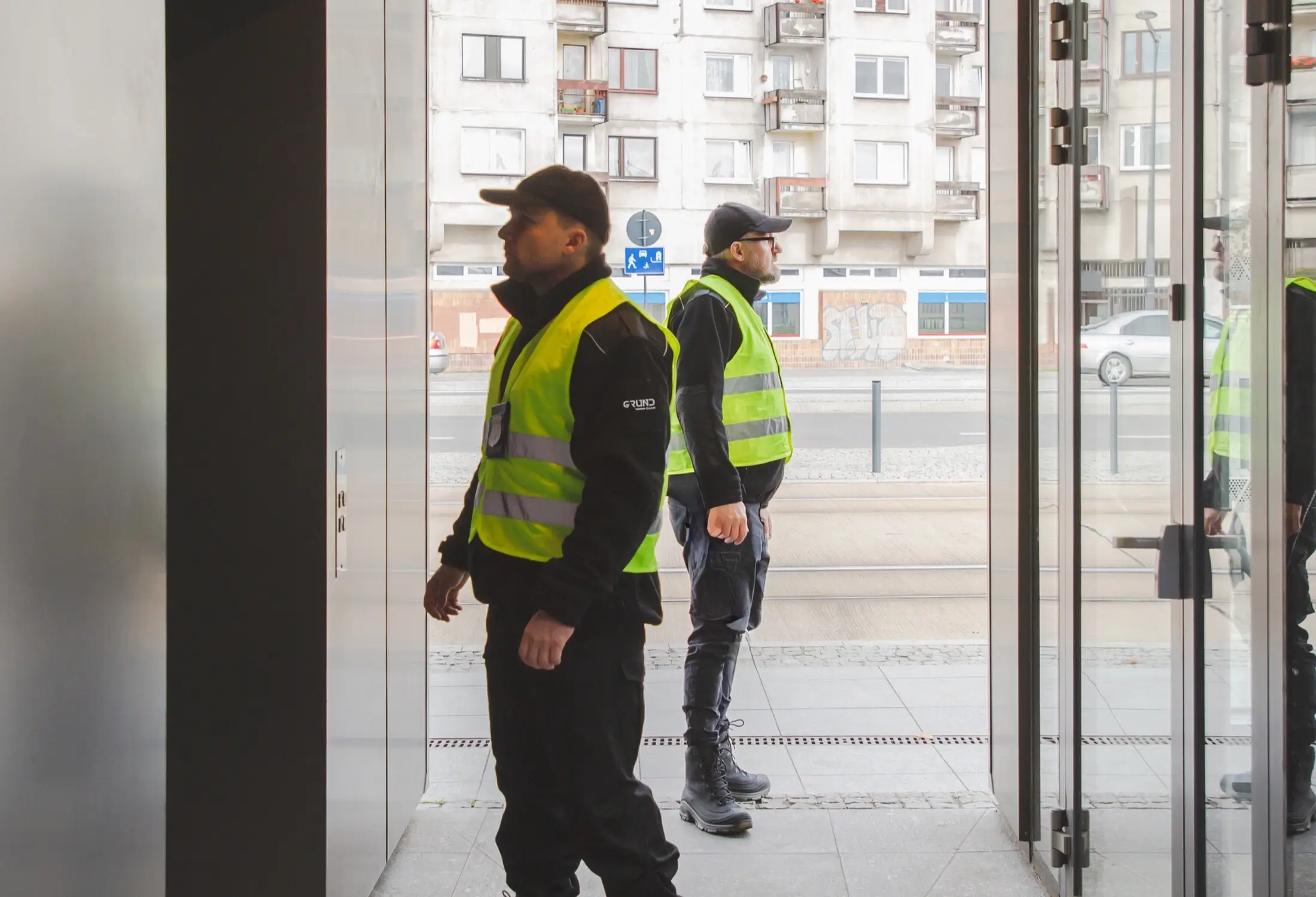 Zwei Mitarbeiter im Objektschutz sichern gemeinsam das Gelände eines gewerblichen Objekts bei Tageseinsatz.